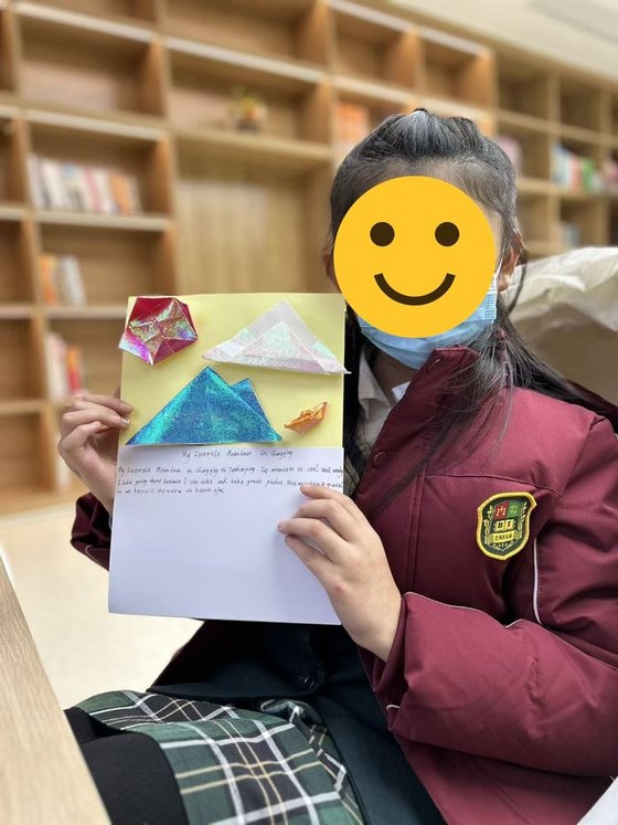 Student holding her artwork about a favourite mountain in Chongqing