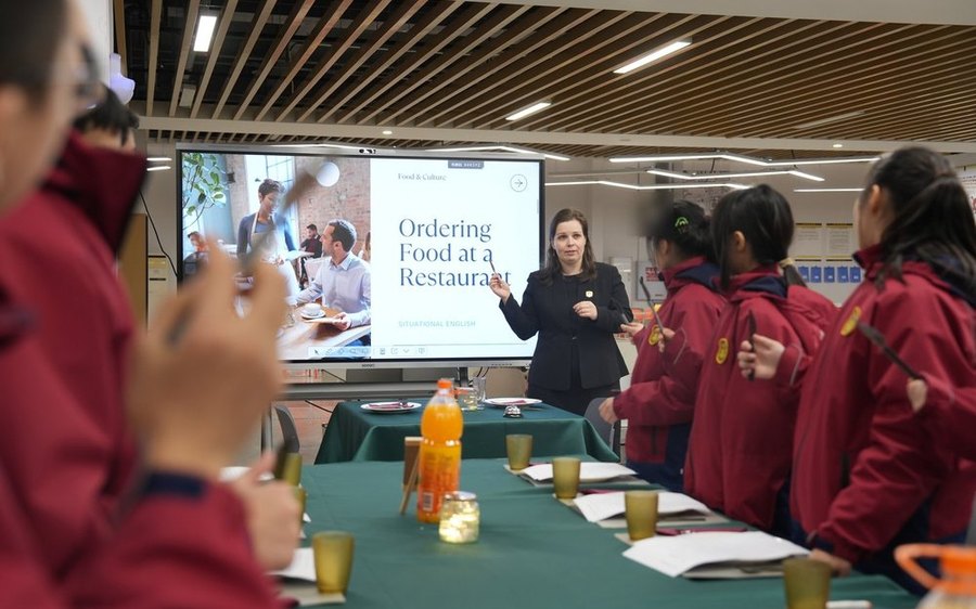 Grade 7 restaurant role-play lesson with tables set up in the classroom