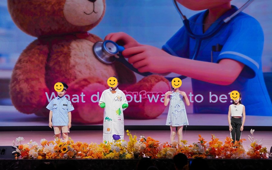 Students performing What Do You Want to Be on stage in costume