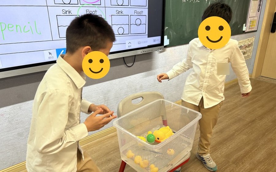Kindergarten students testing objects in a water tub during the Sink or Float lesson